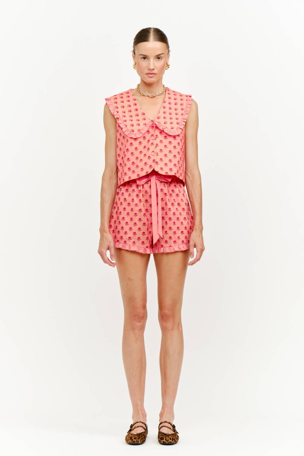 Woman wearing a pink polka dot outfit on a white background