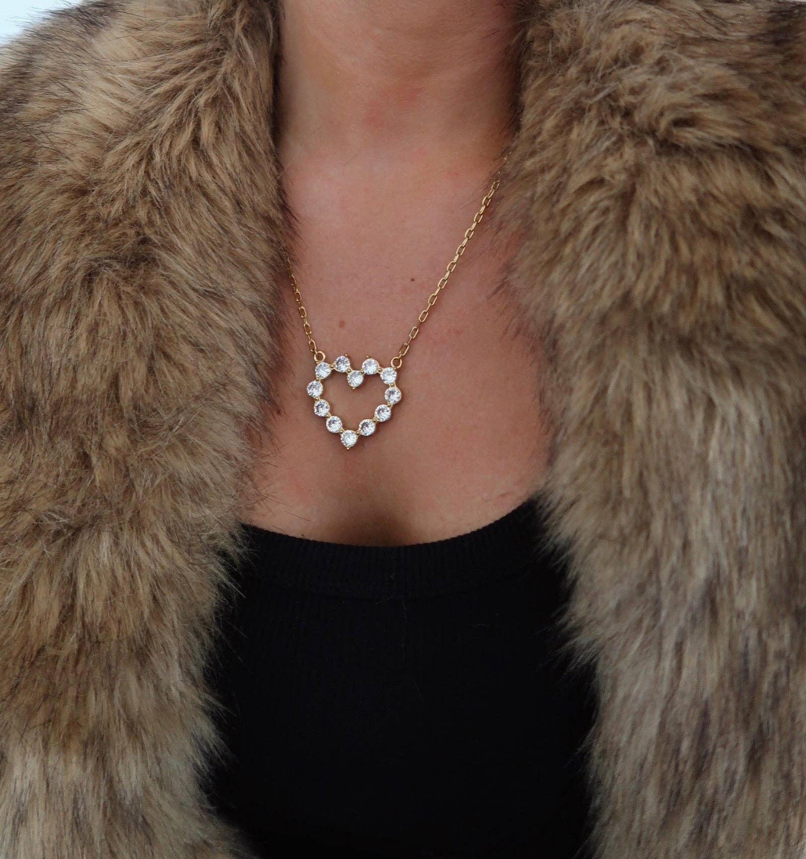 Heart-shaped diamond necklace worn with a fur coat