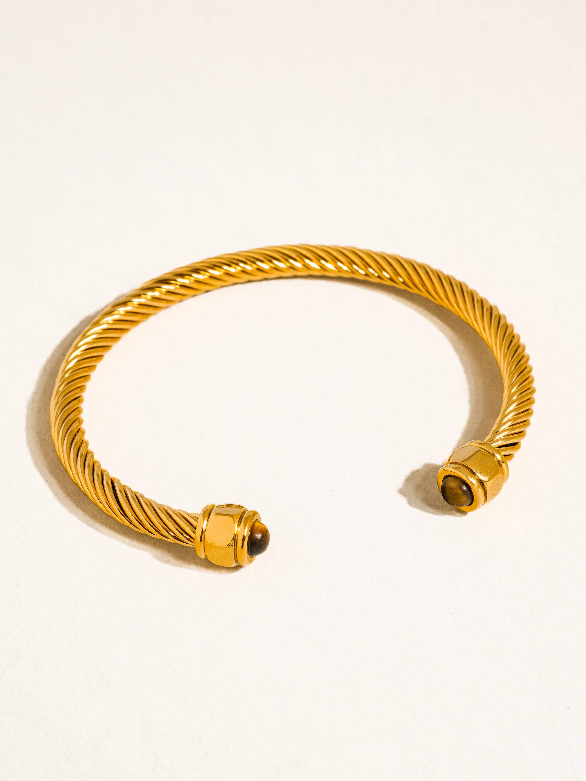 Gold bracelet on a light beige background