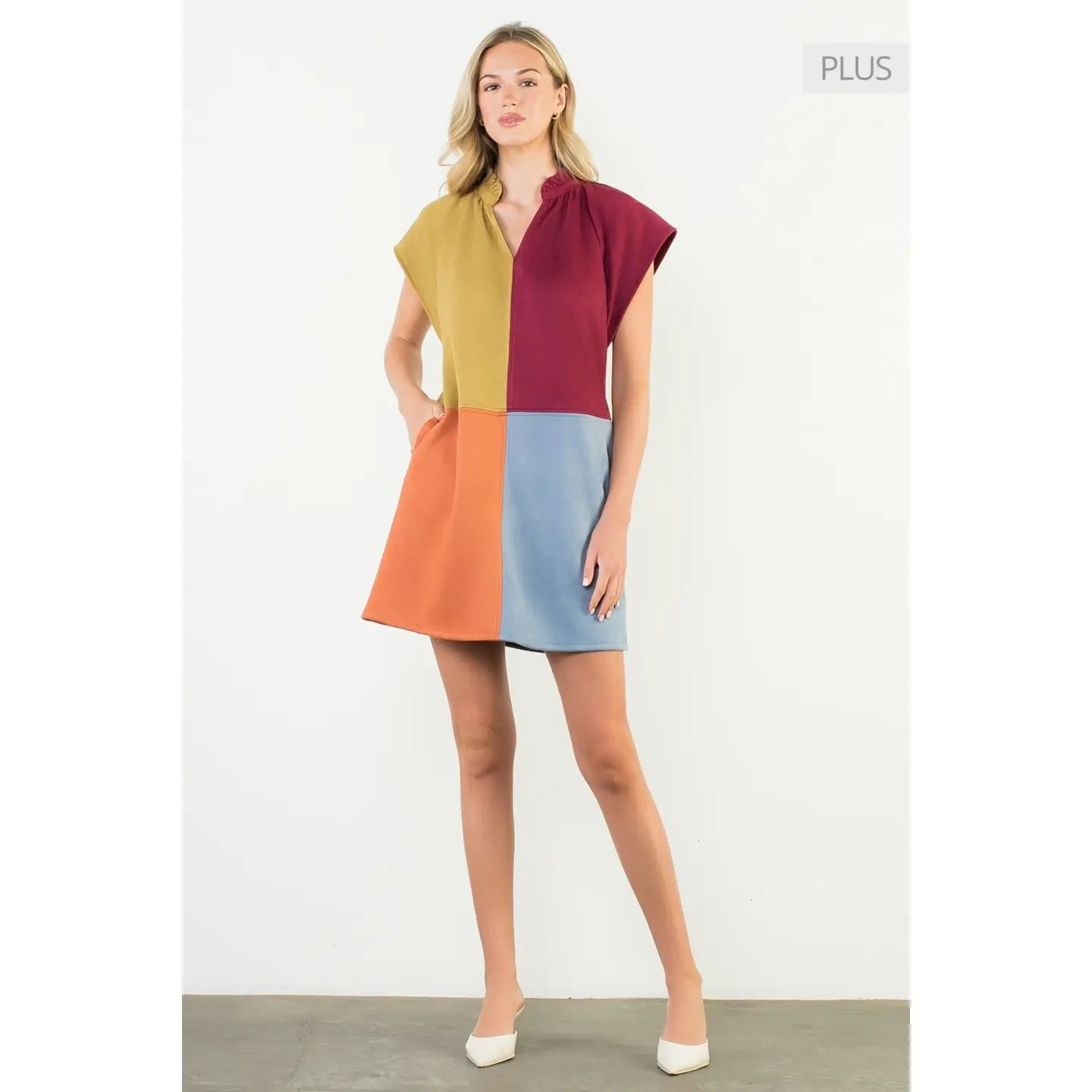 Woman wearing a colorful dress with a plain background