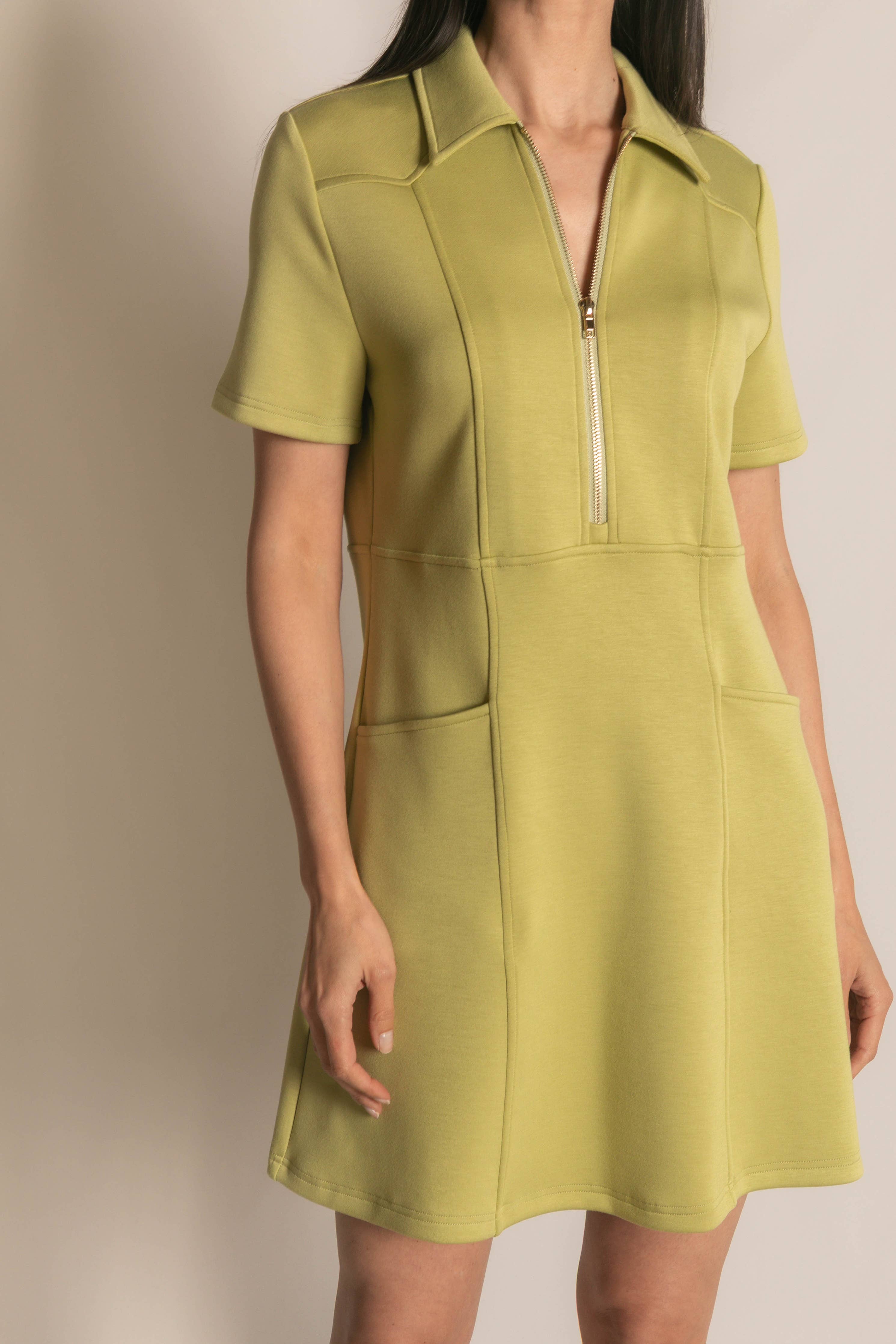 Green dress with short sleeves and a zipper on a neutral background
