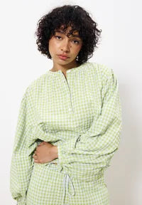 Person wearing a green checkered outfit against a white background