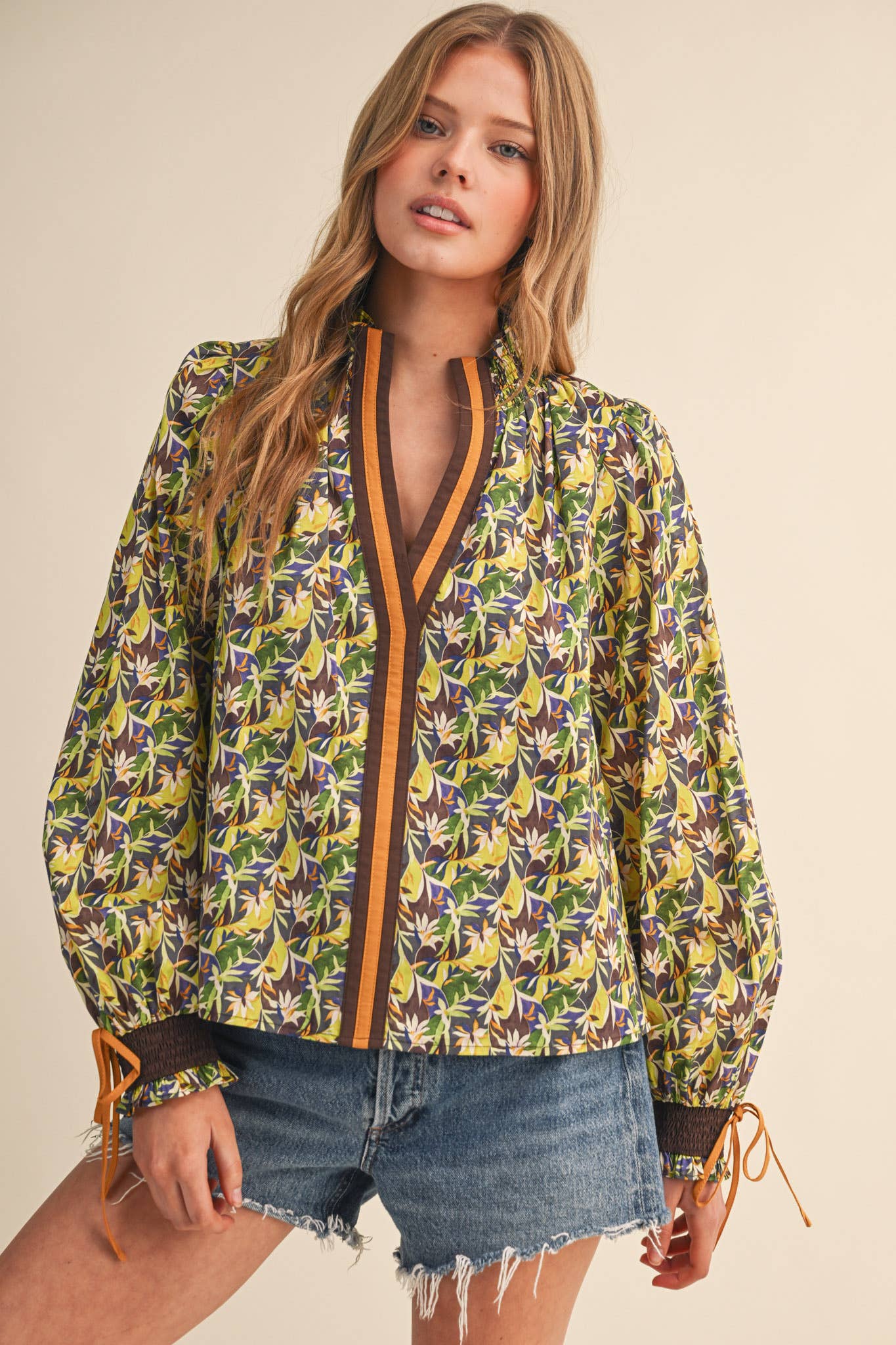 Woman wearing a colorful floral jacket with a beige background