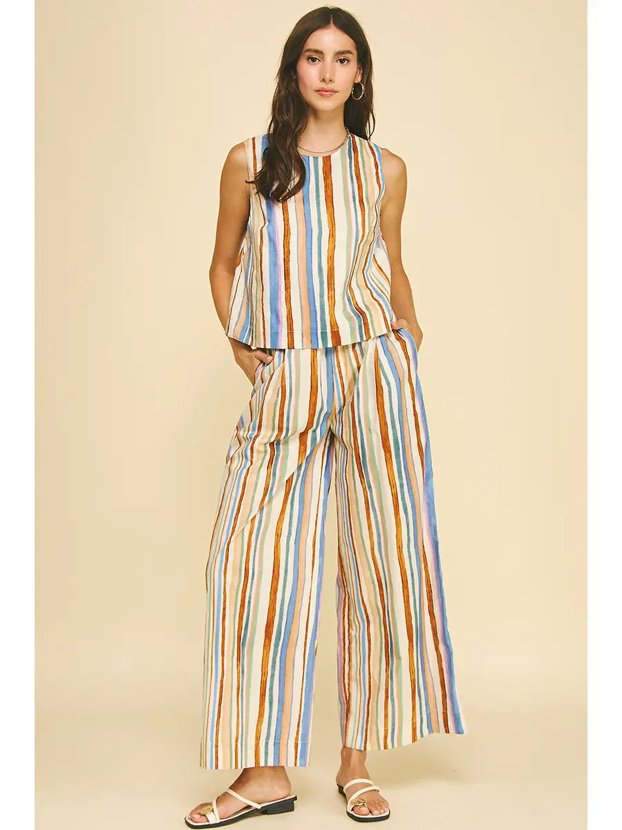 Woman wearing a colorful striped jumpsuit on a beige background