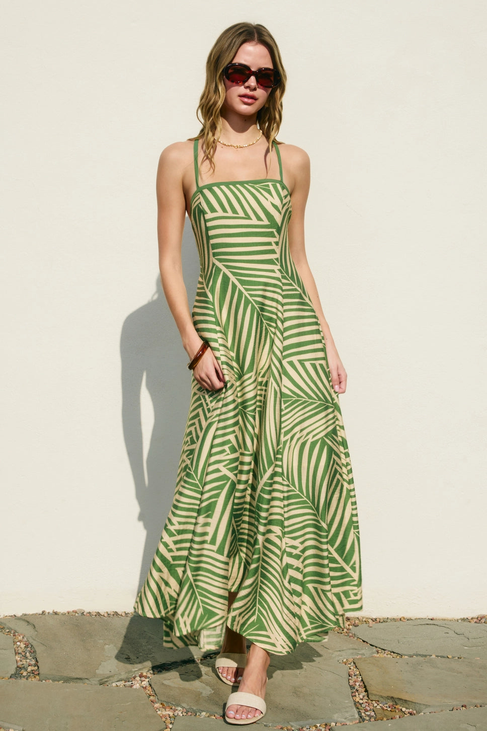 Woman wearing a green and white striped dress against a plain background