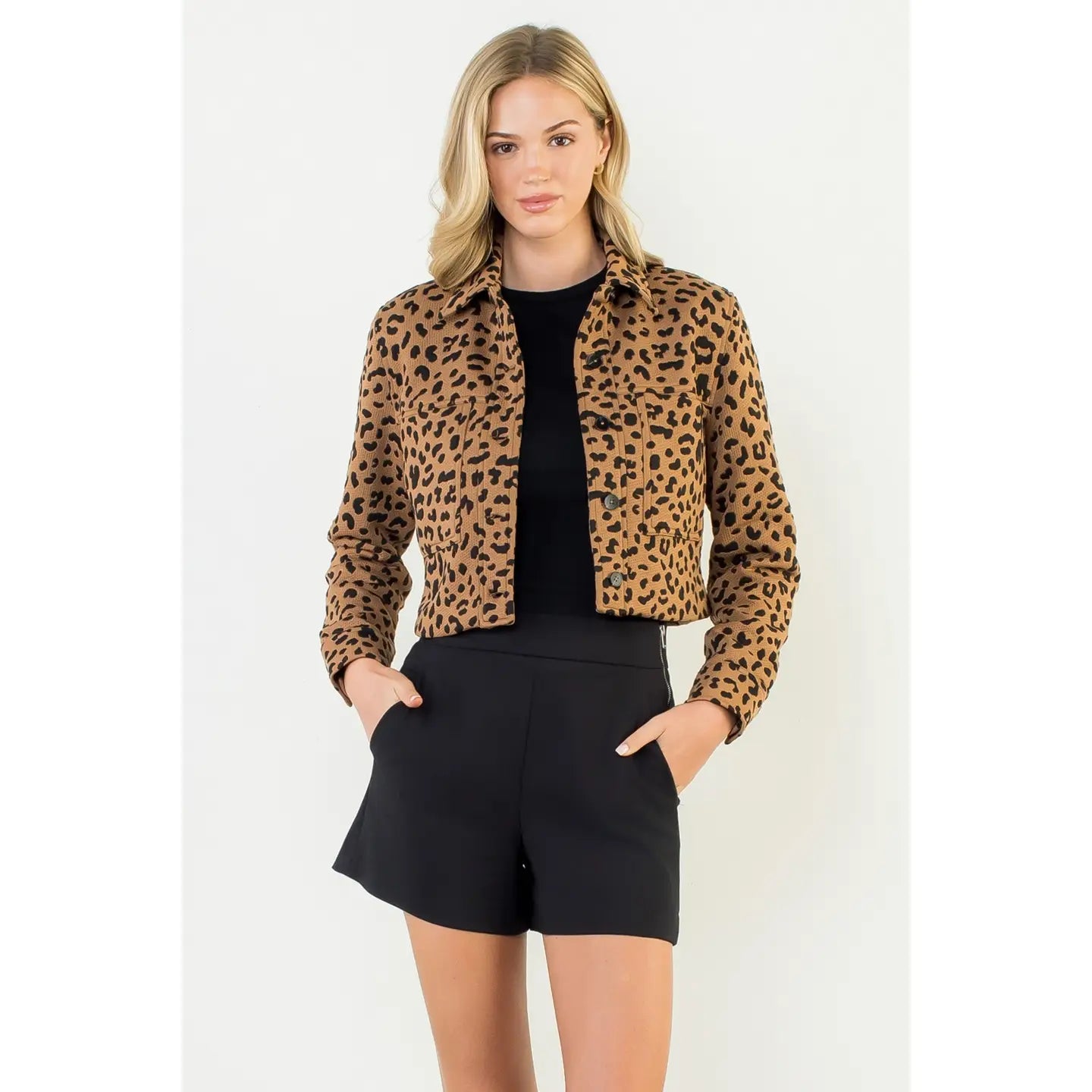 Woman wearing a leopard print jacket and black shorts on a white background
