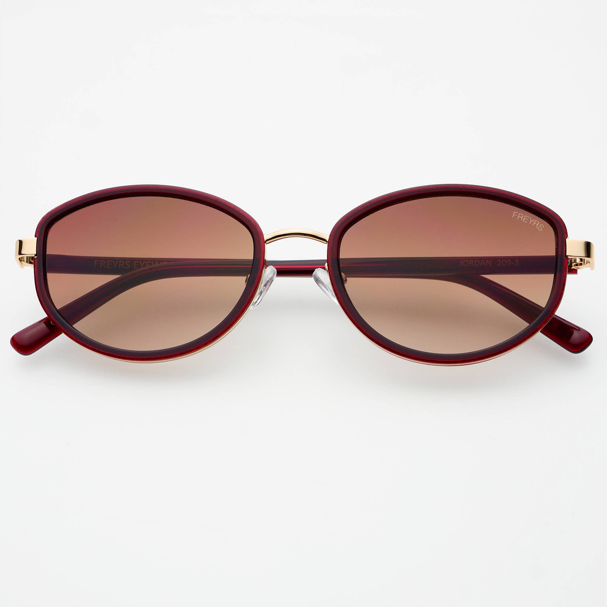 Sunglasses with maroon frames and brown lenses on a white background