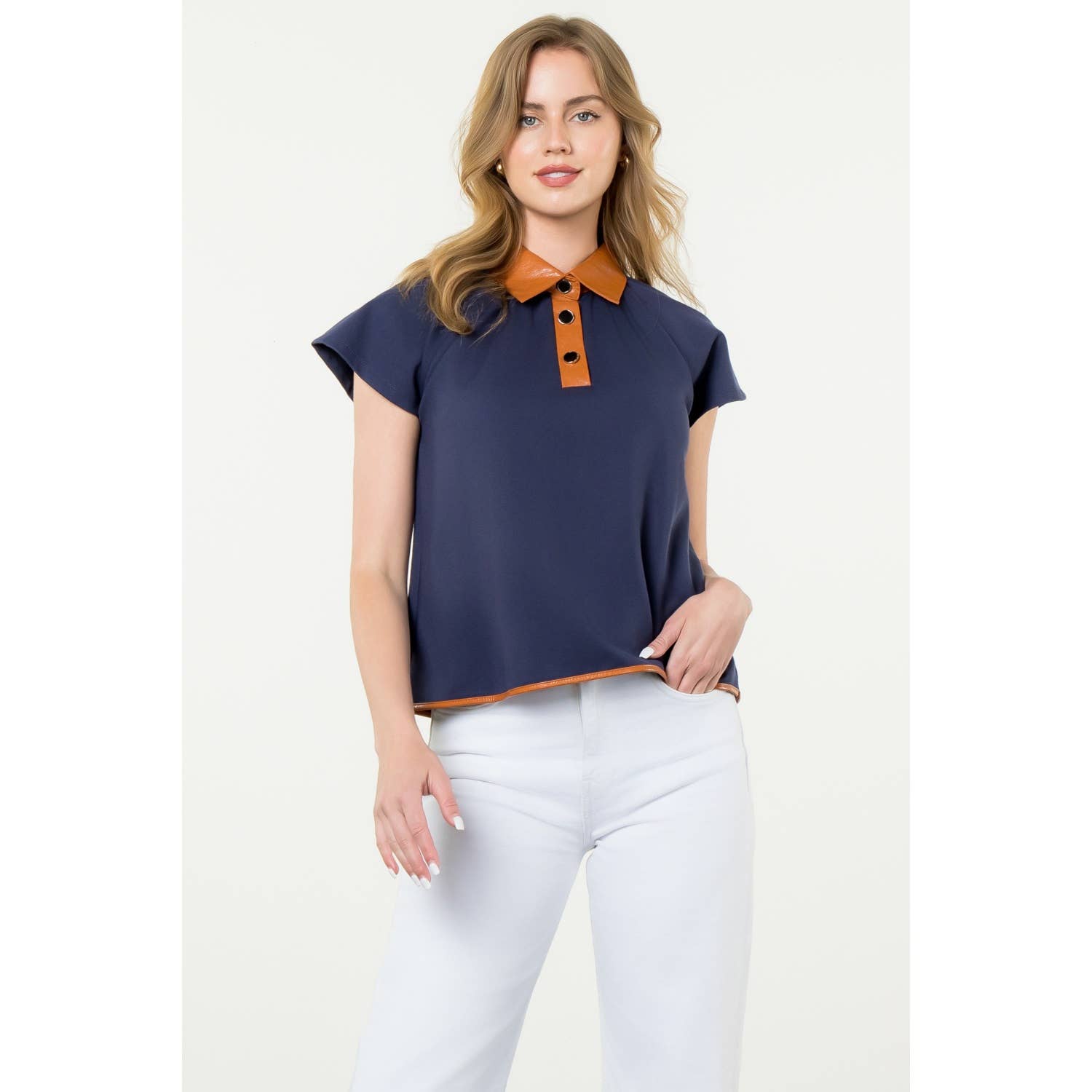 Woman wearing a navy blue top with an orange collar on a white background