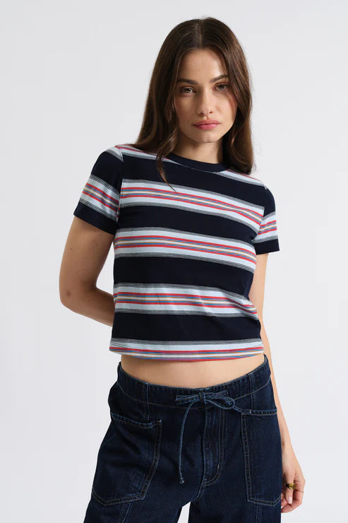 Woman wearing a striped crop top and dark jeans on a white background