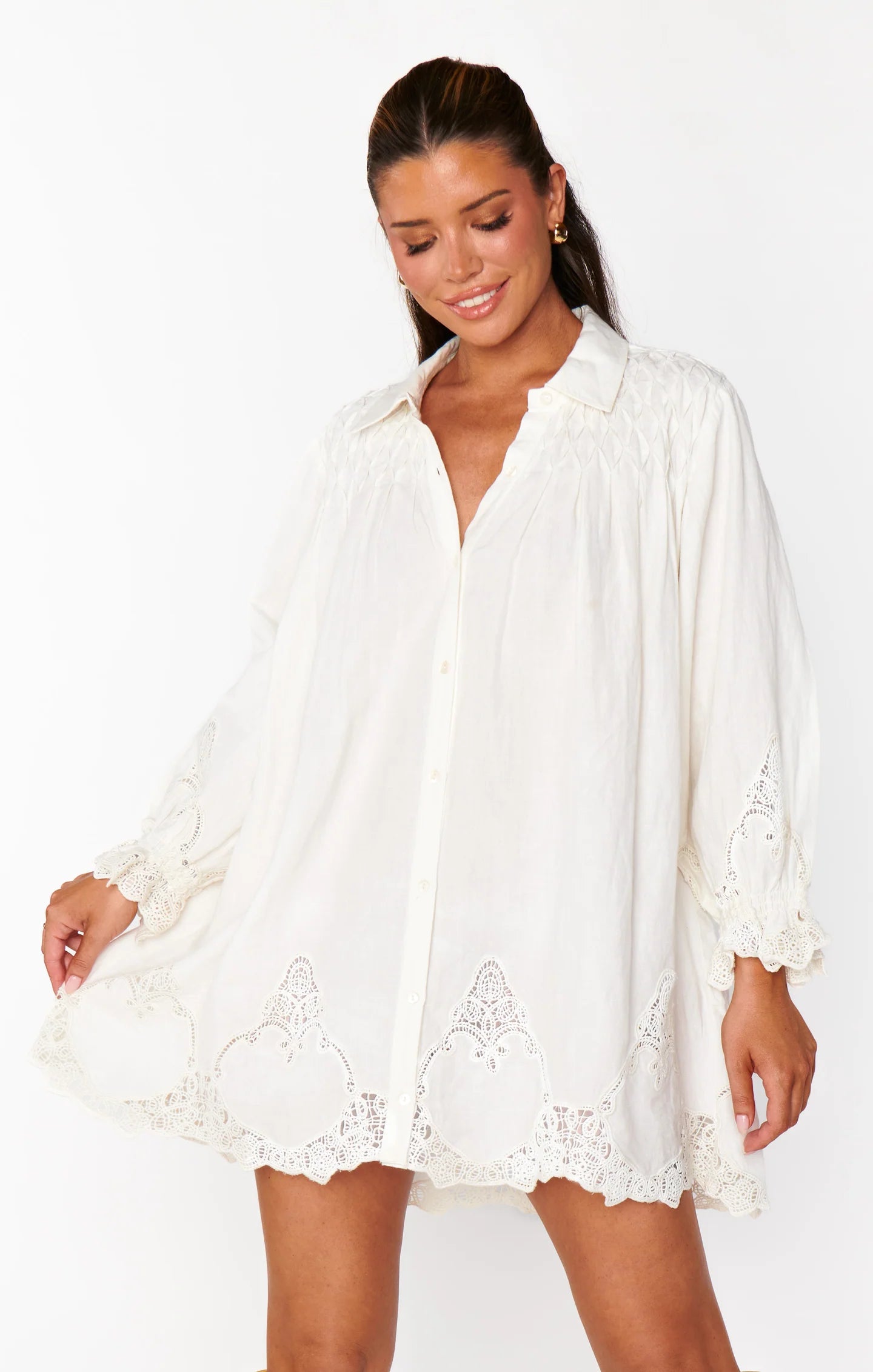 Woman wearing a white lace dress on a plain background