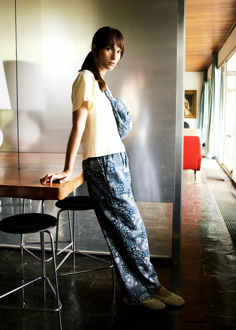Woman in a modern interior setting with a table and chair