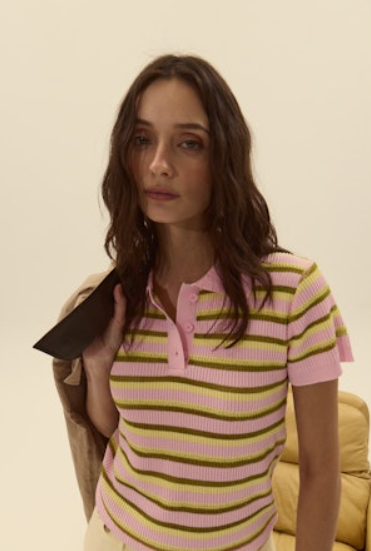 Woman wearing a pink and yellow striped shirt against a plain background