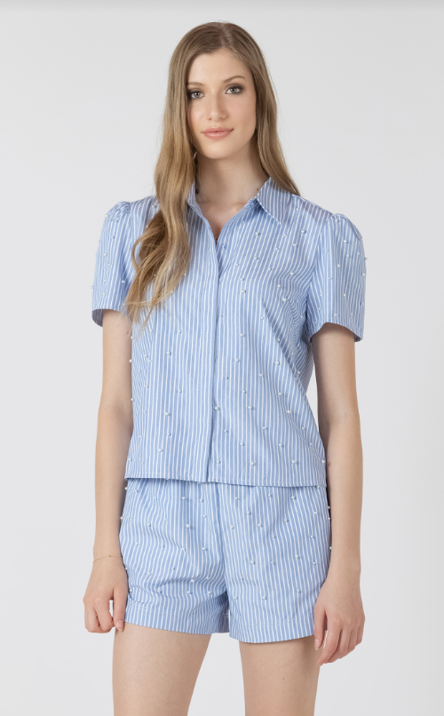 Woman wearing a blue and white striped shirt and shorts set on a white background