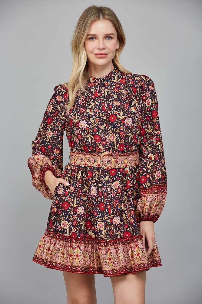 Woman wearing a floral dress with long sleeves on a gray background