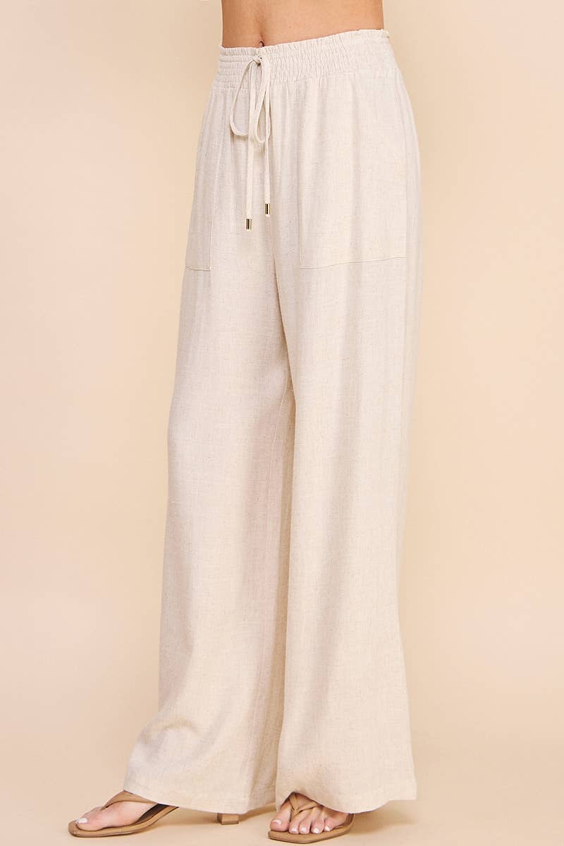 Beige wide-leg pants with drawstring waist on a beige background