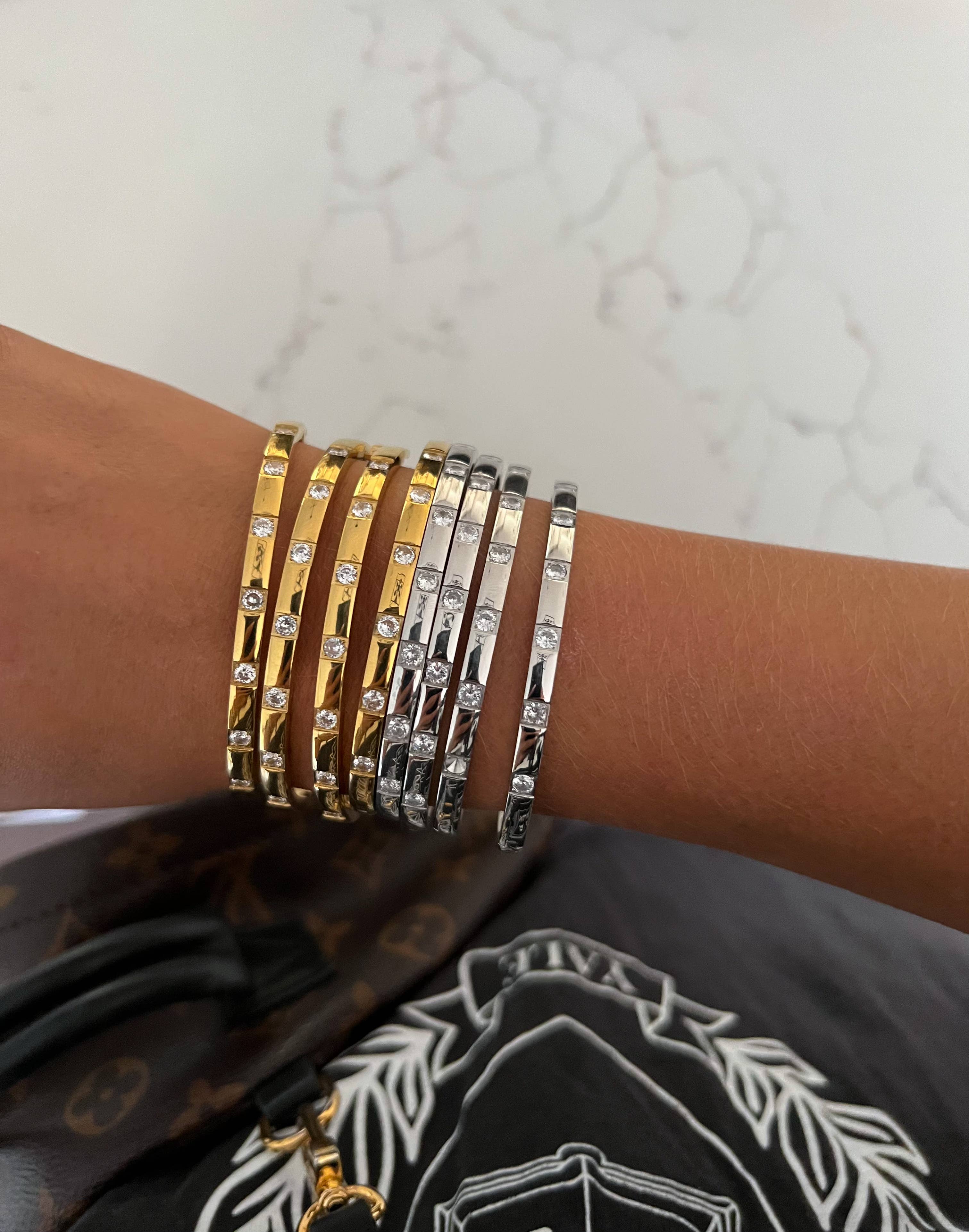 Multiple bracelets on a wrist with a marble background