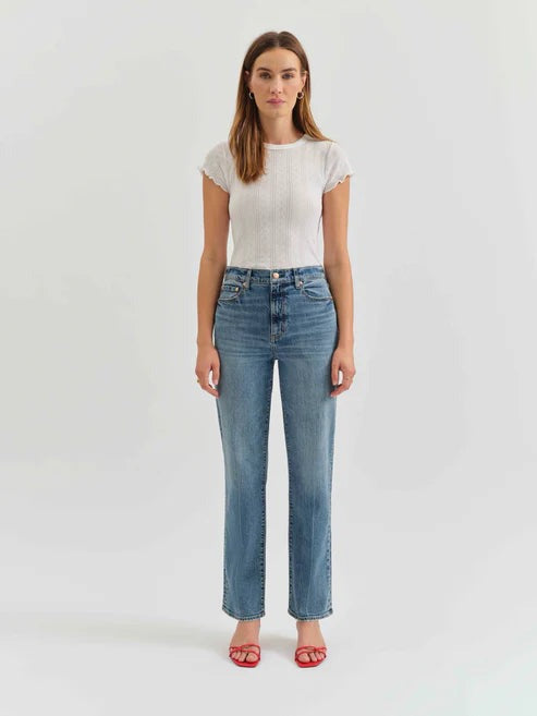 Woman wearing a white t-shirt and blue jeans on a white background