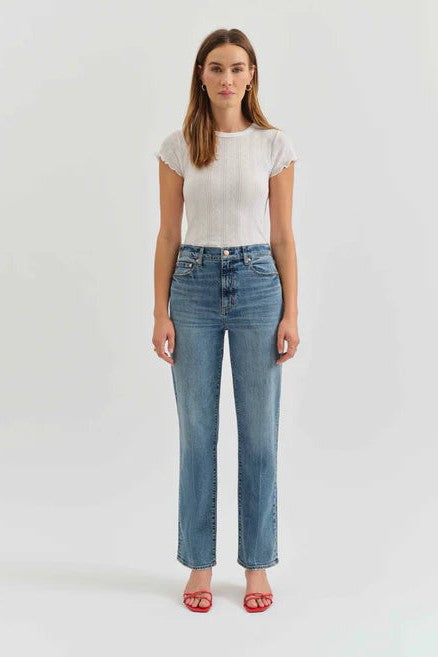 Woman wearing a white t-shirt and blue jeans on a white background