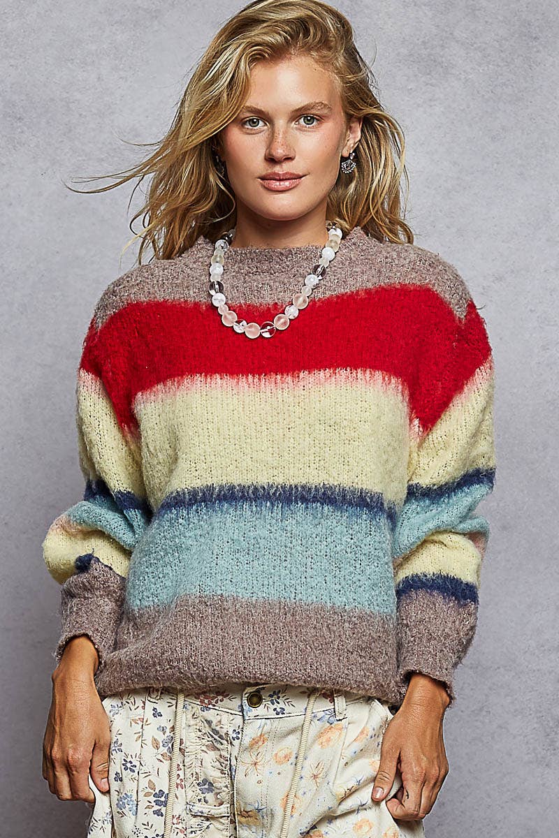 Woman wearing a colorful striped sweater against a gray background