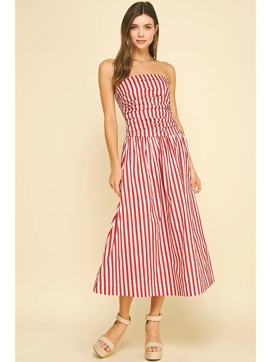 Woman wearing a red and white striped dress on a beige background