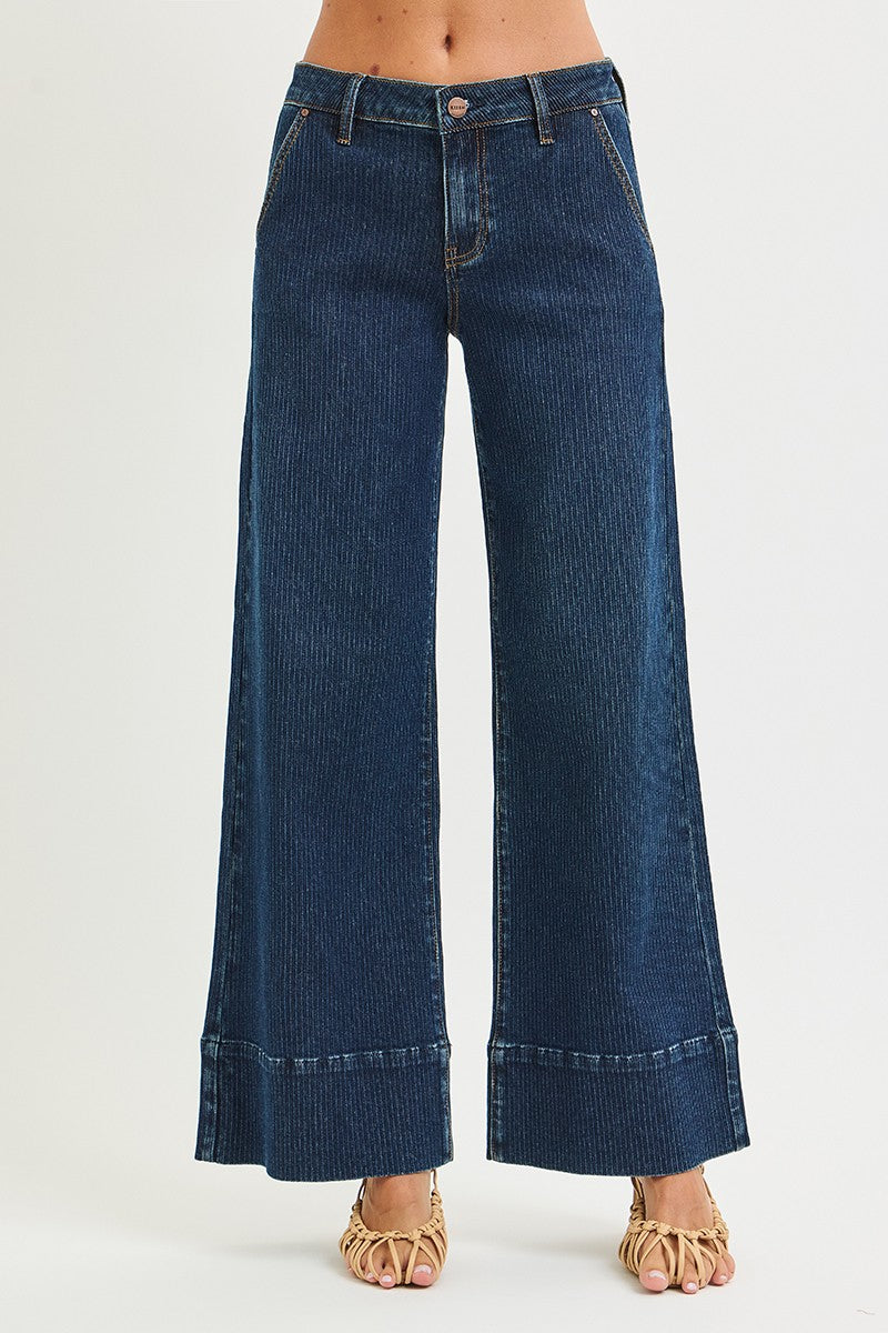 Blue wide-leg jeans worn by a person on a white background