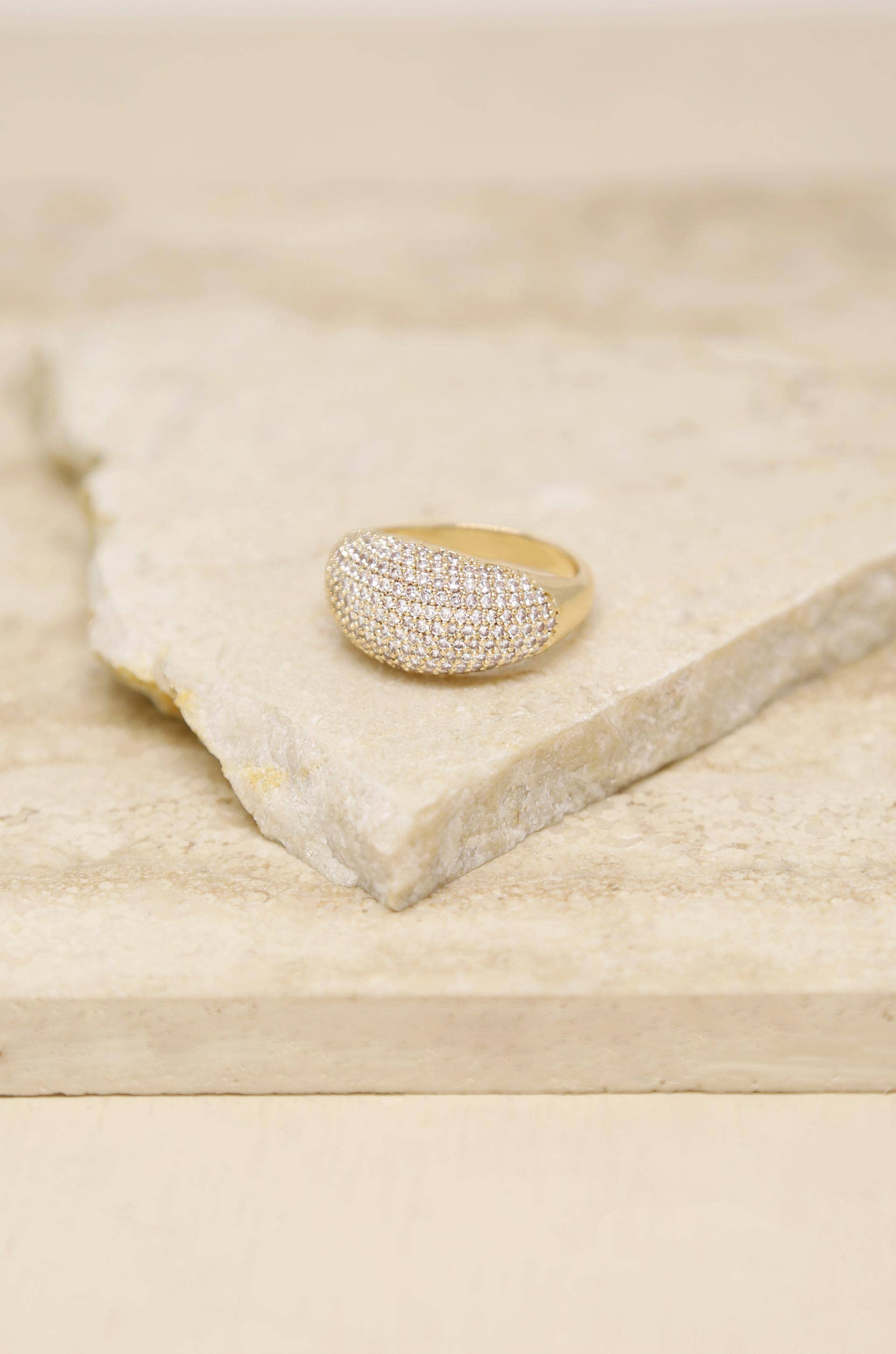 Gold ring with diamonds on a light wooden surface