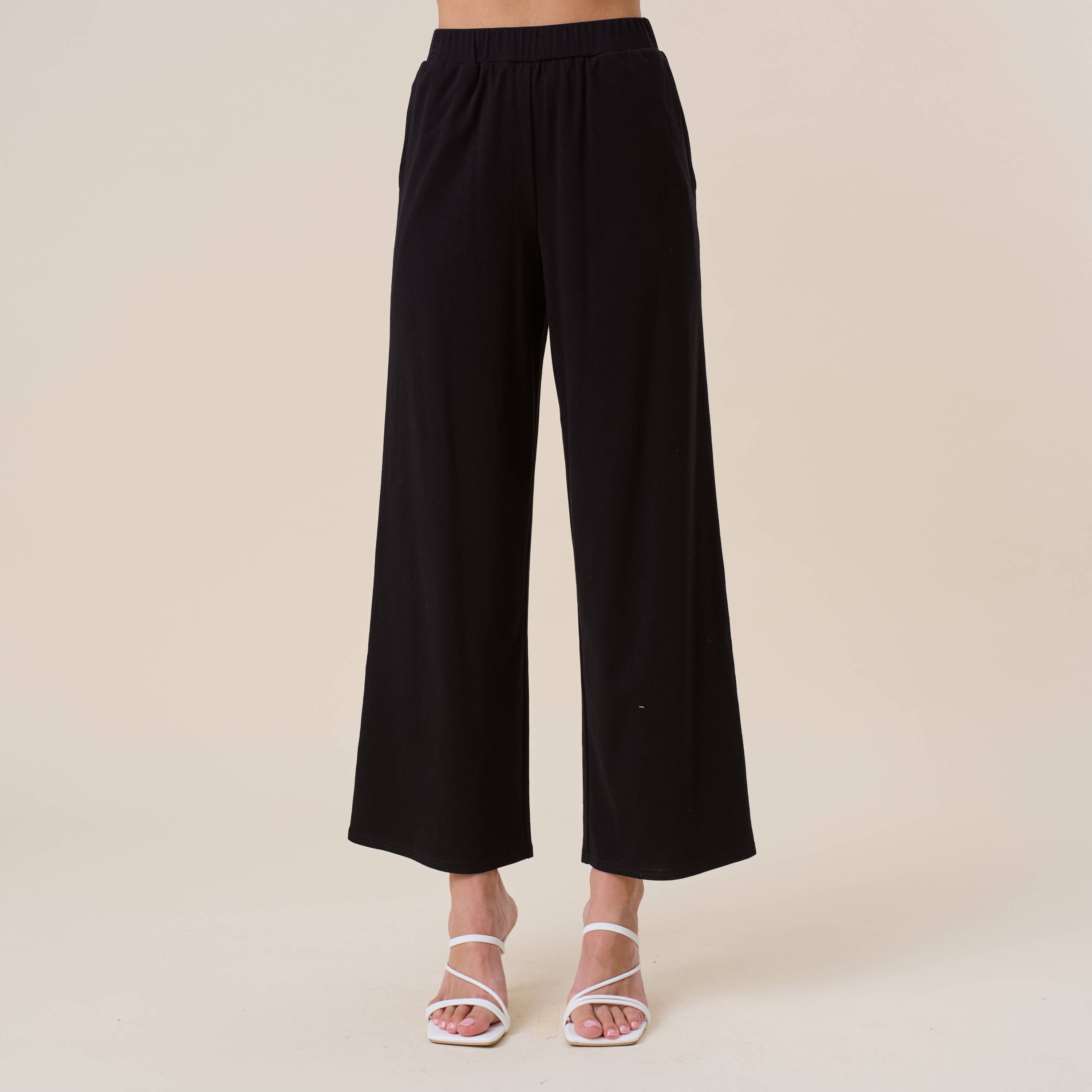 Black wide-leg pants on a neutral background