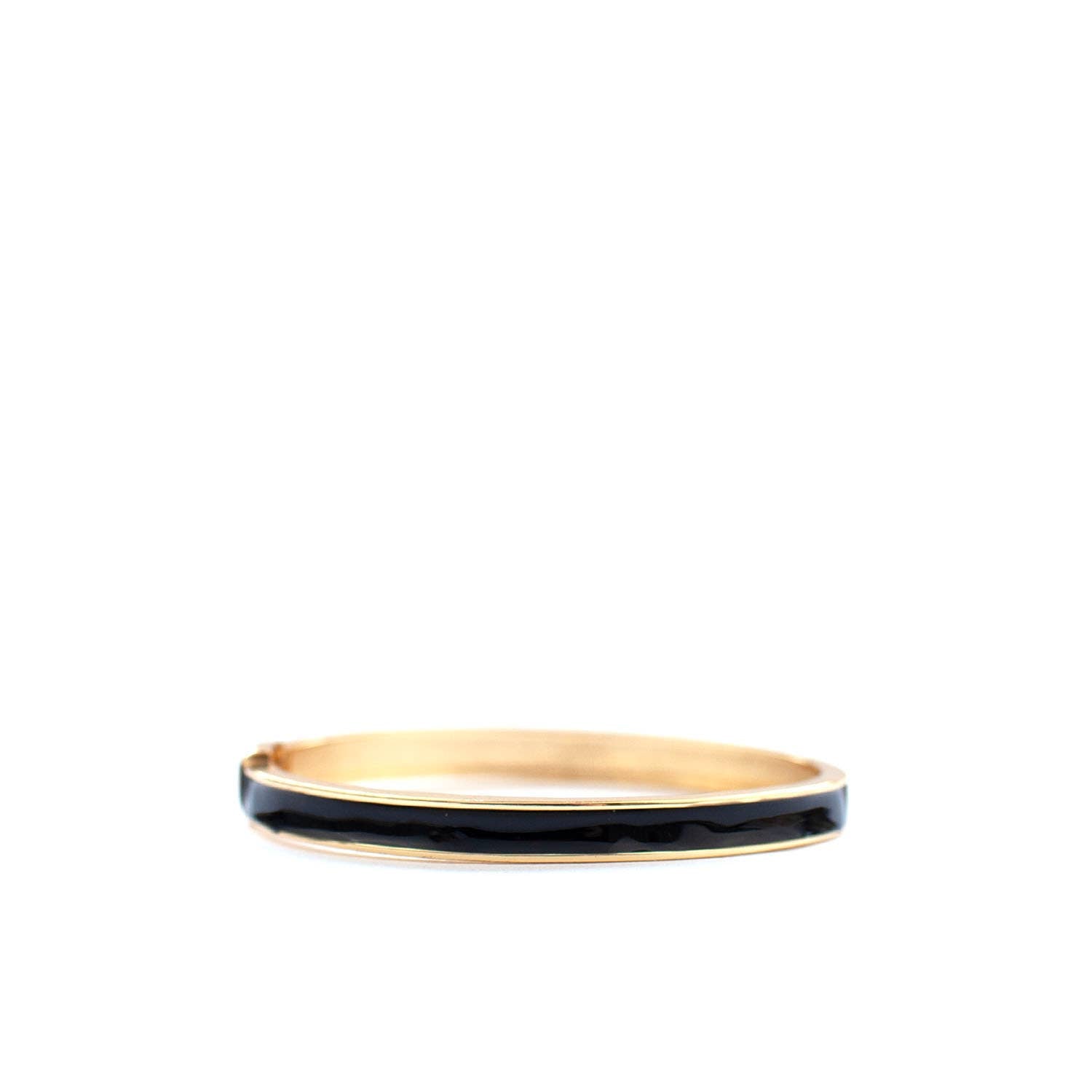 Gold bangle with black enamel inlay on a white background