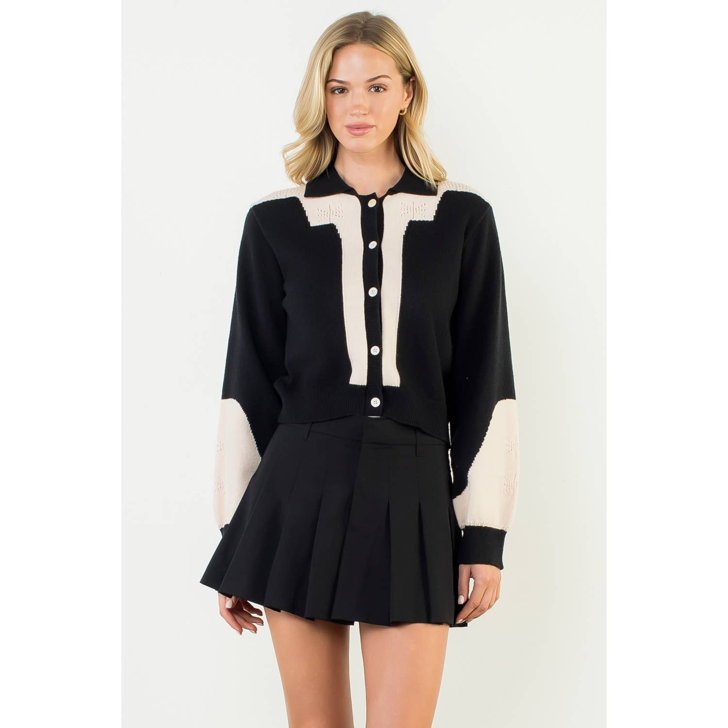 Woman wearing a black and white outfit with a skirt on a white background