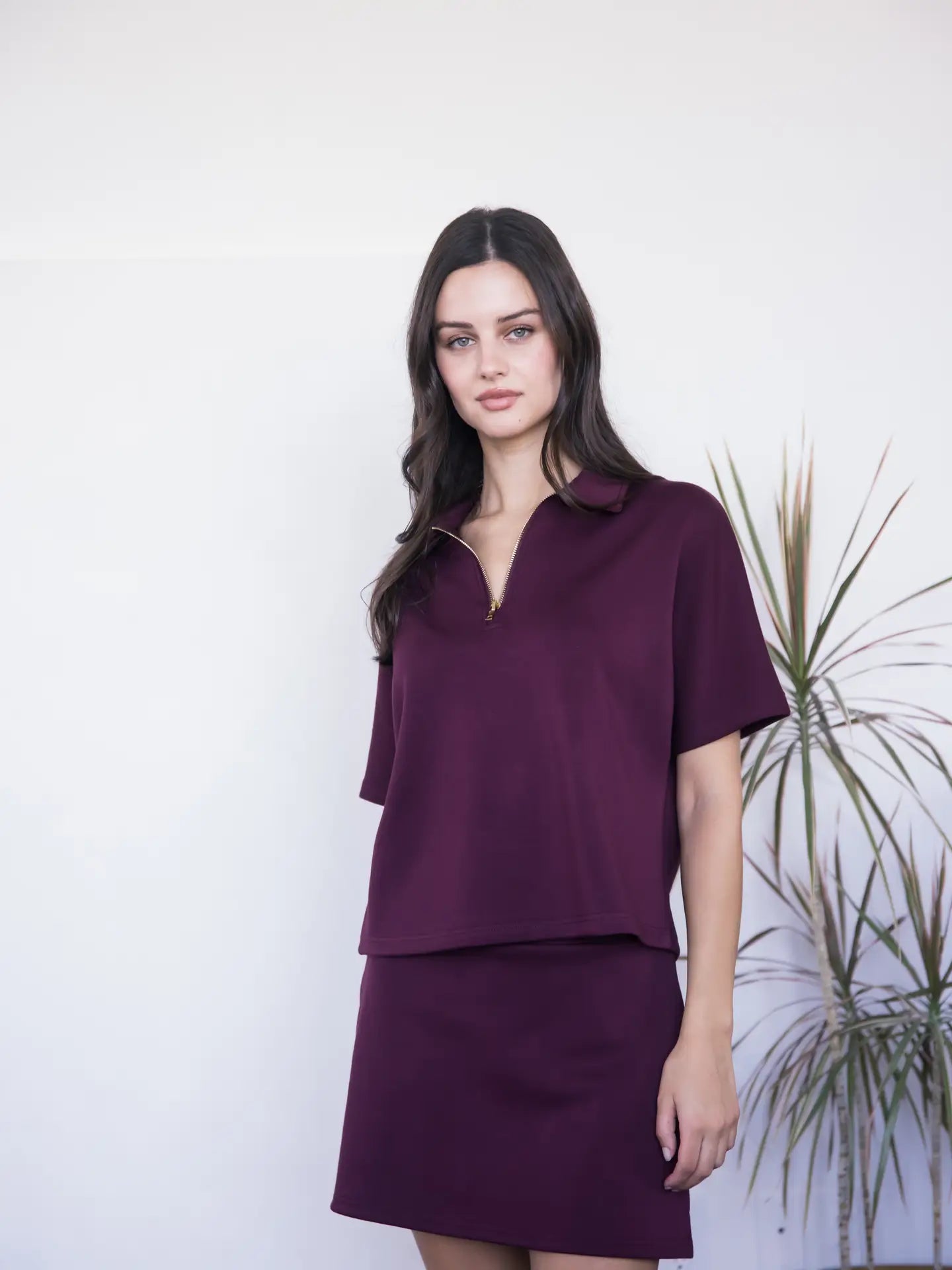 Woman wearing a purple outfit against a white background