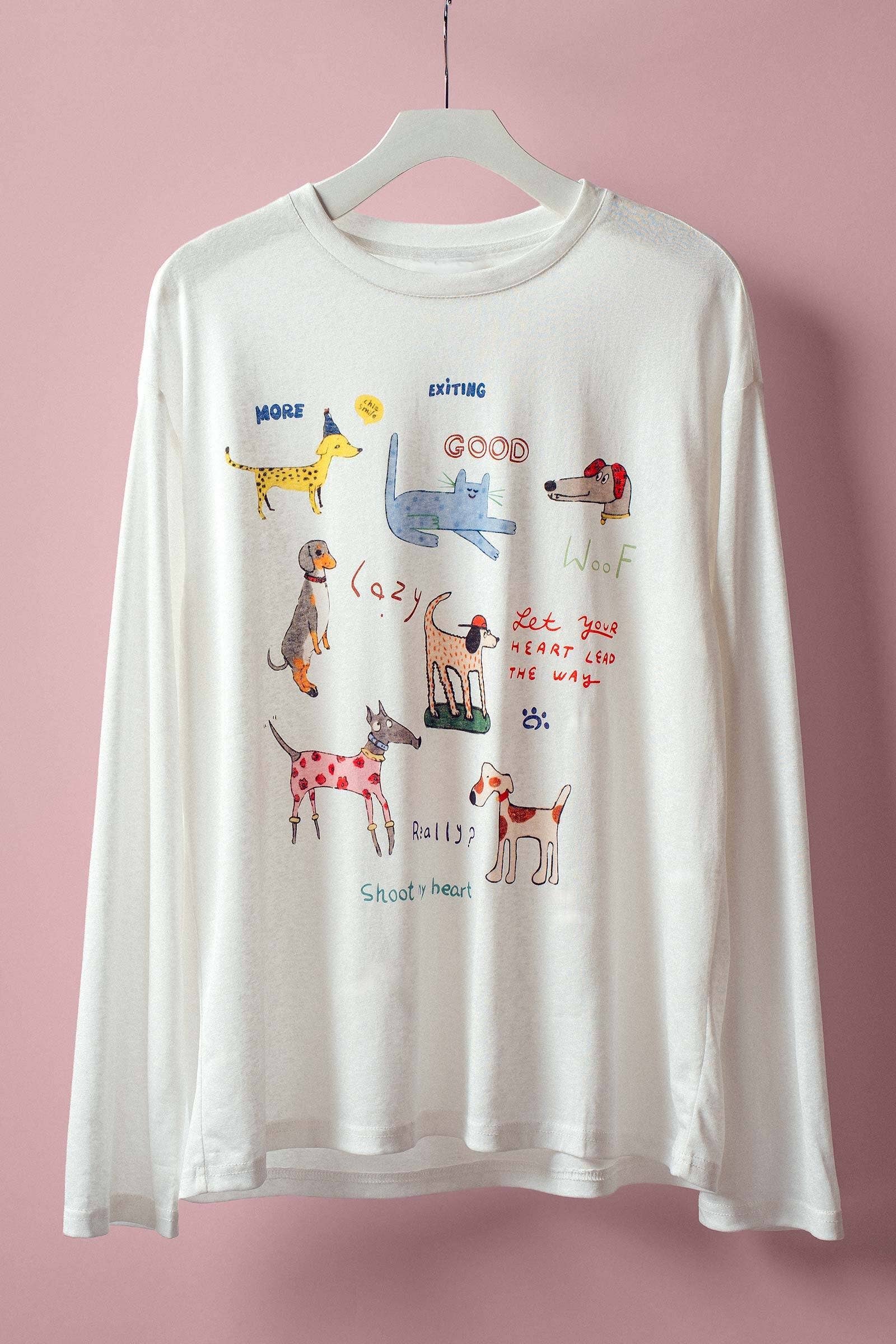 White long-sleeve shirt with colorful dog illustrations on a pink background