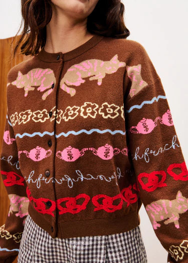 Brown cardigan with pink cat pattern worn by a person