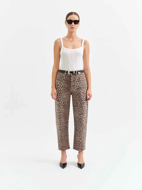 Woman wearing leopard print pants and a white top on a white background