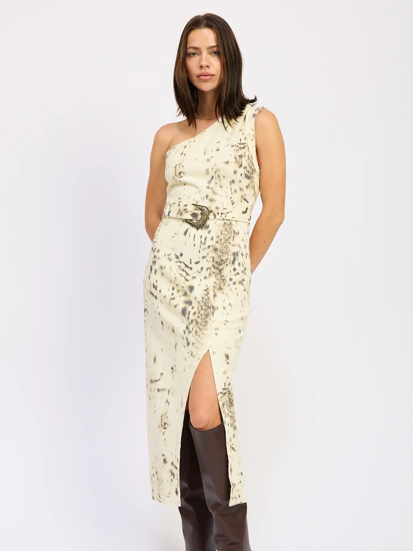 Woman wearing a one-shoulder dress with a floral pattern on a white background