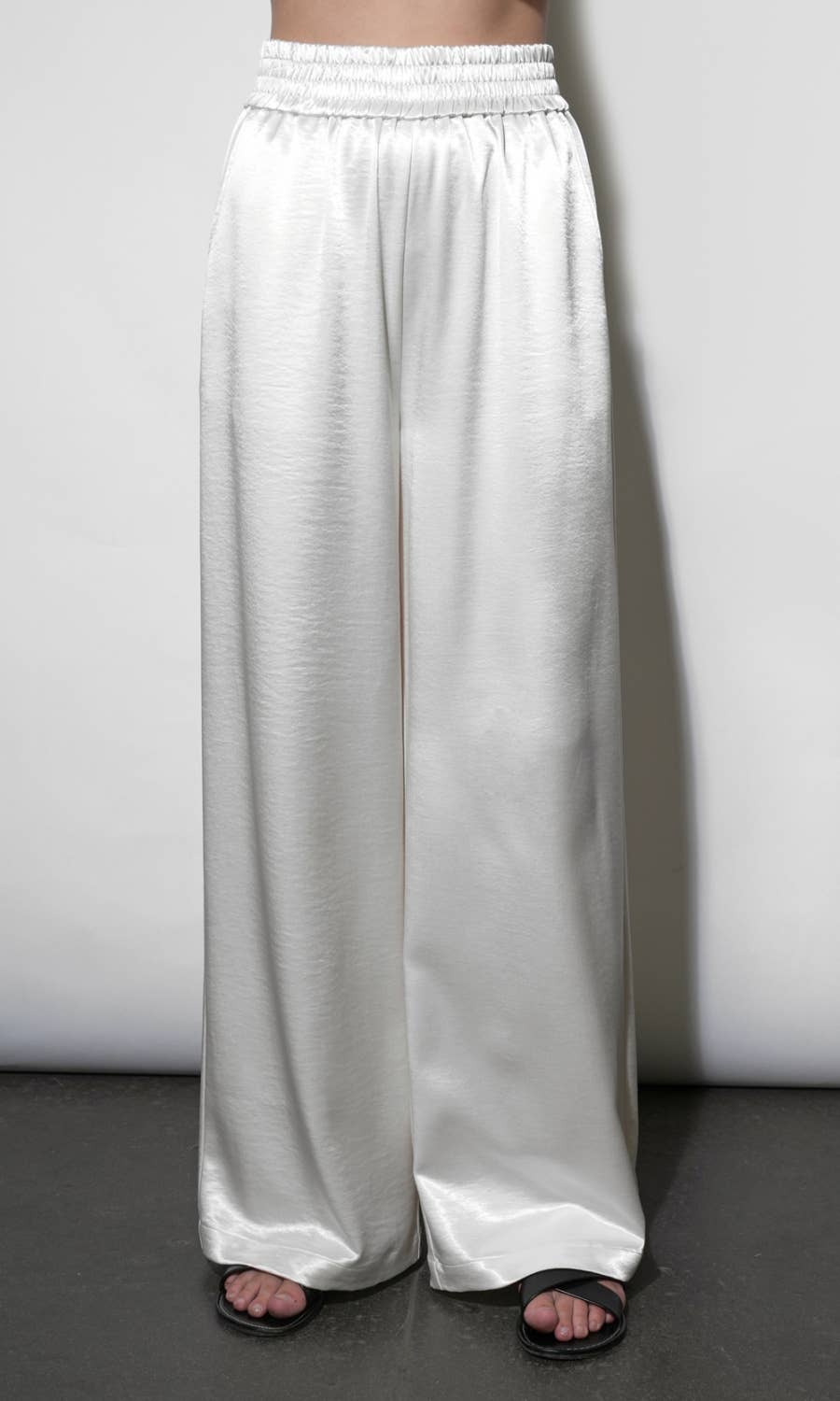White wide-leg pants worn by a person on a plain background