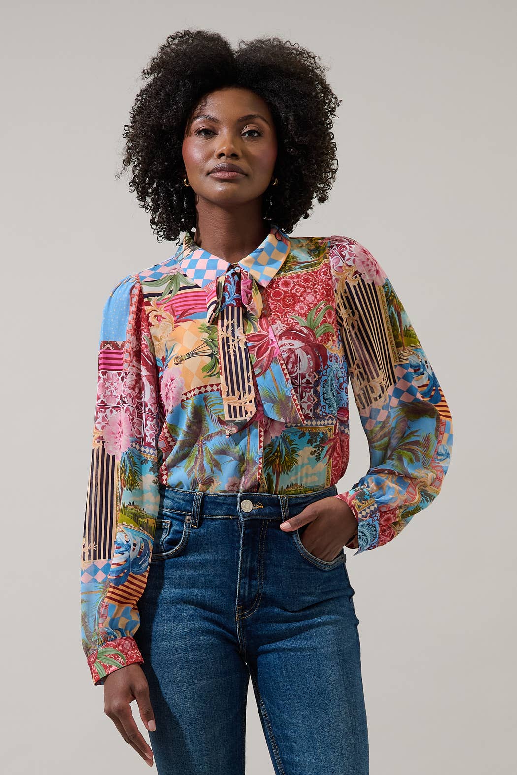 Woman wearing a colorful patterned shirt with a plain background