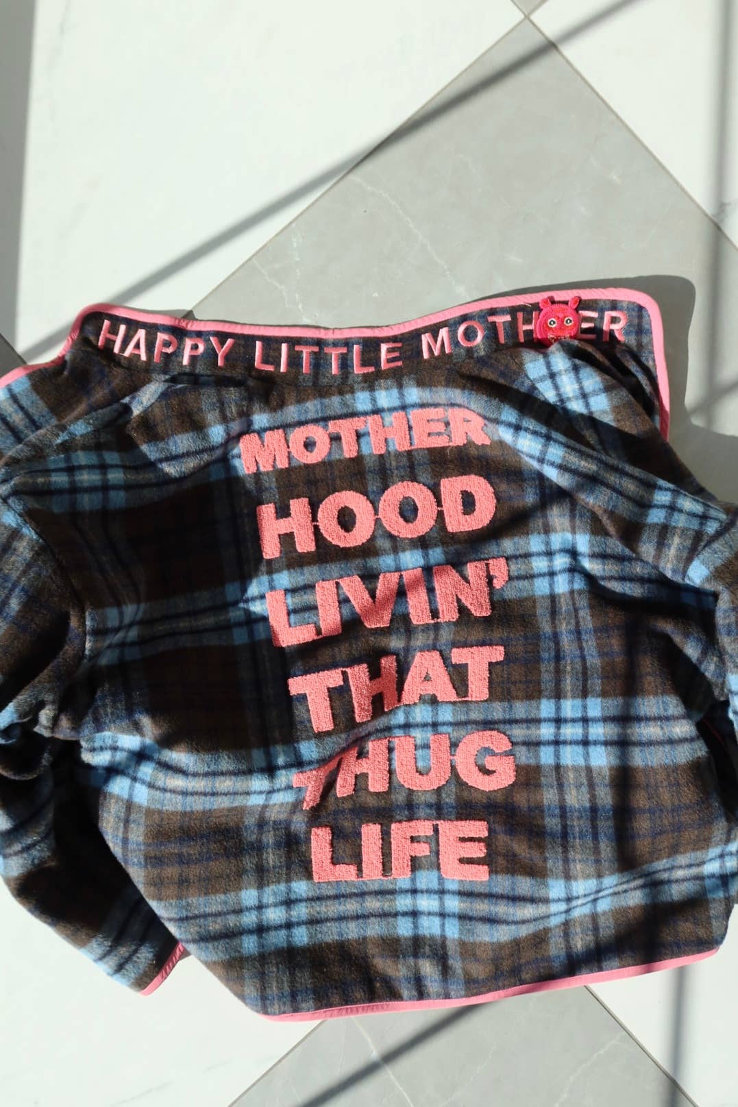 Plaid baby blanket with text on a white background