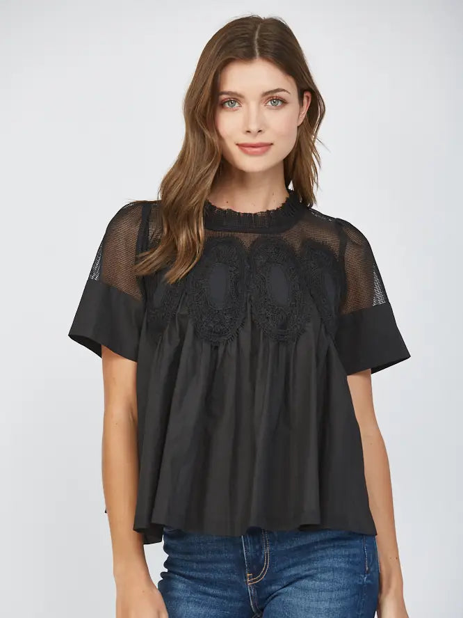 Woman wearing a black lace top and blue jeans on a white background