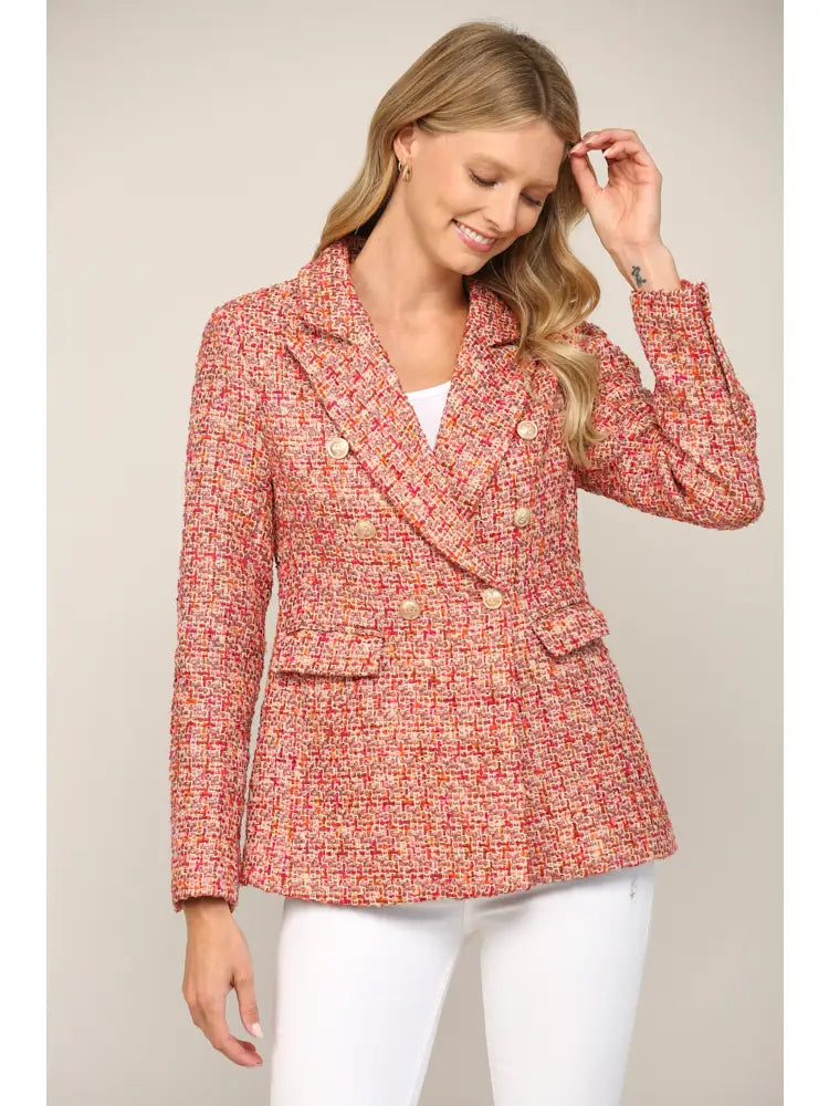Woman wearing a red and pink patterned jacket against a plain background