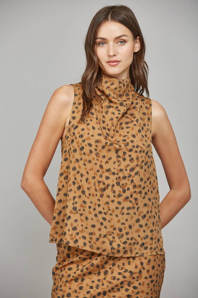 Woman wearing a leopard print sleeveless top against a gray background