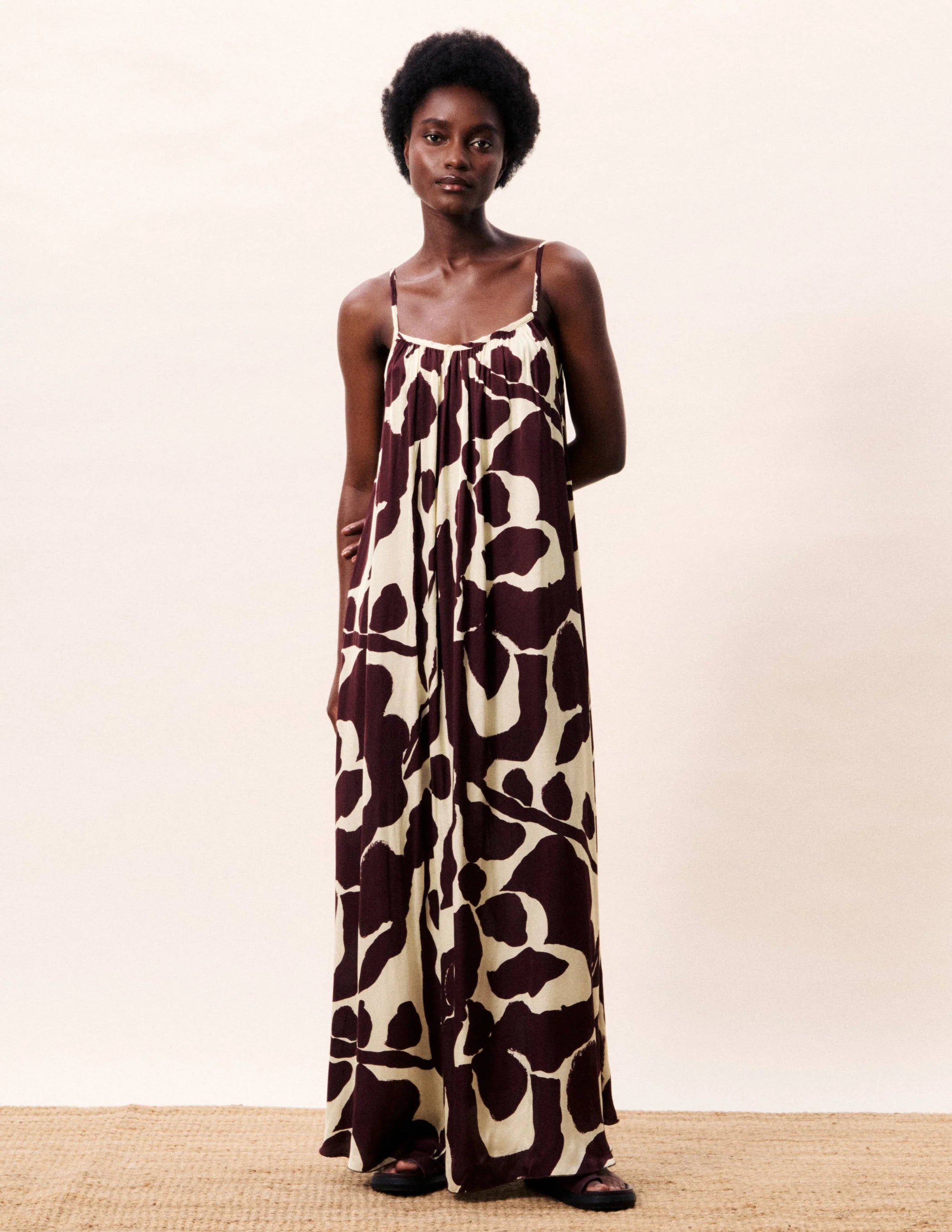 Woman wearing a patterned dress on a plain background