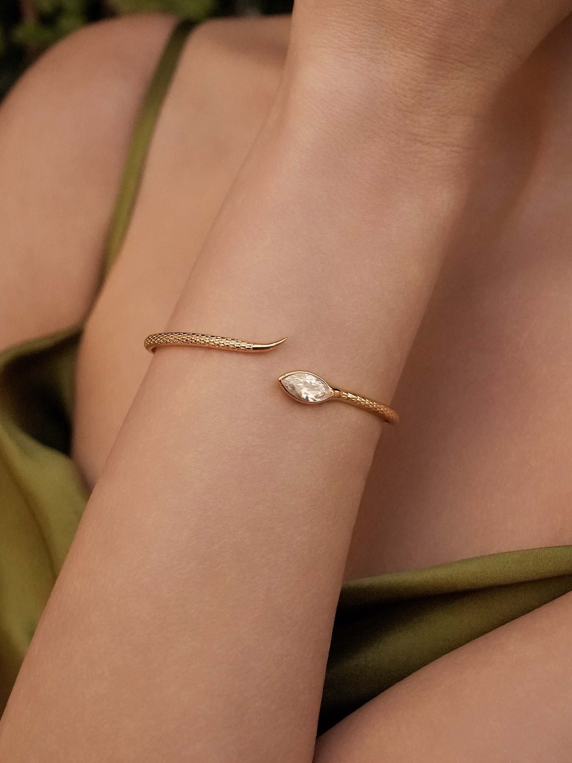 Gold bracelet on a person's wrist with a soft background