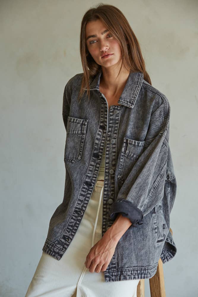 Woman wearing a denim jacket against a plain background