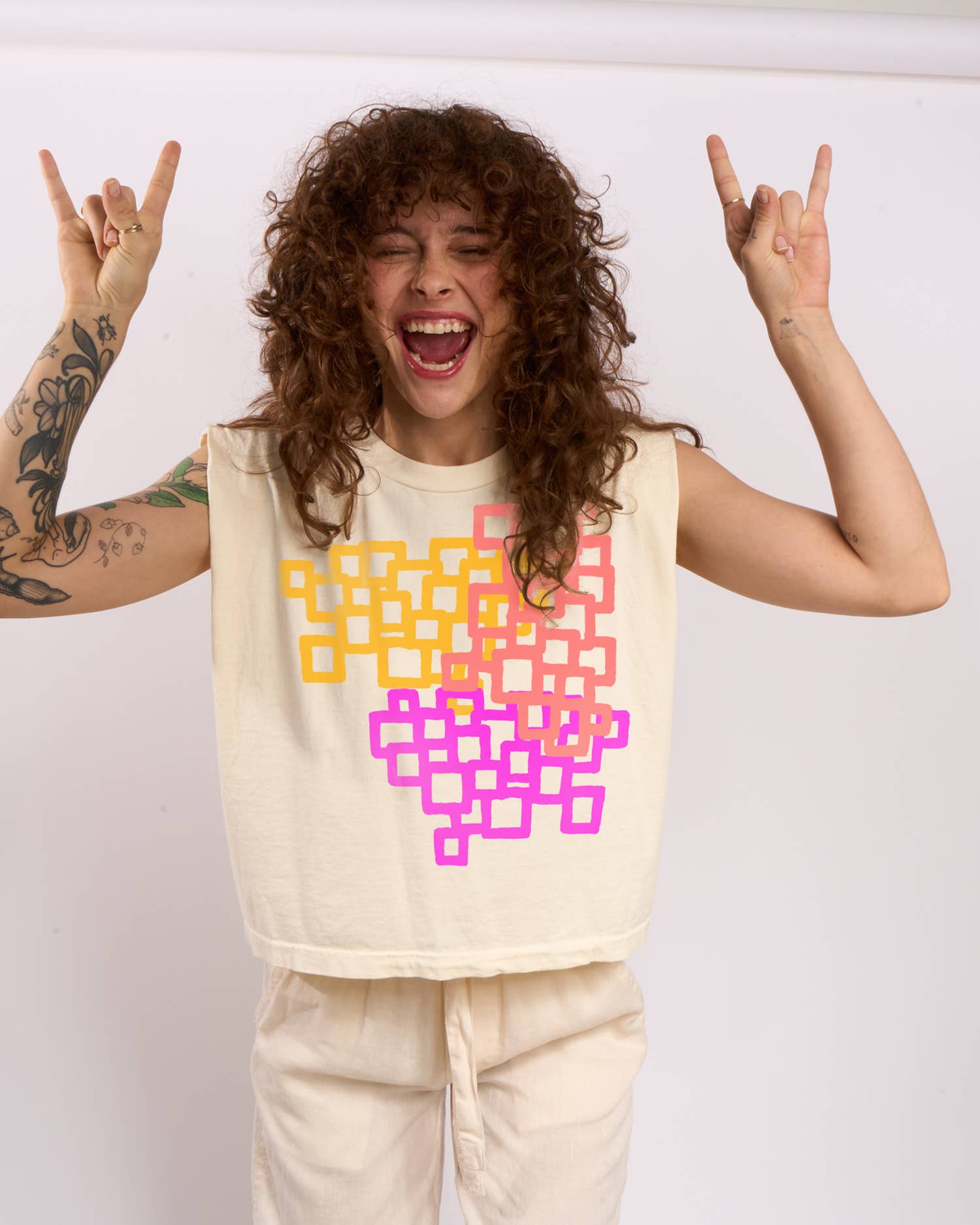 Person wearing a sleeveless top with colorful geometric pattern on a plain background