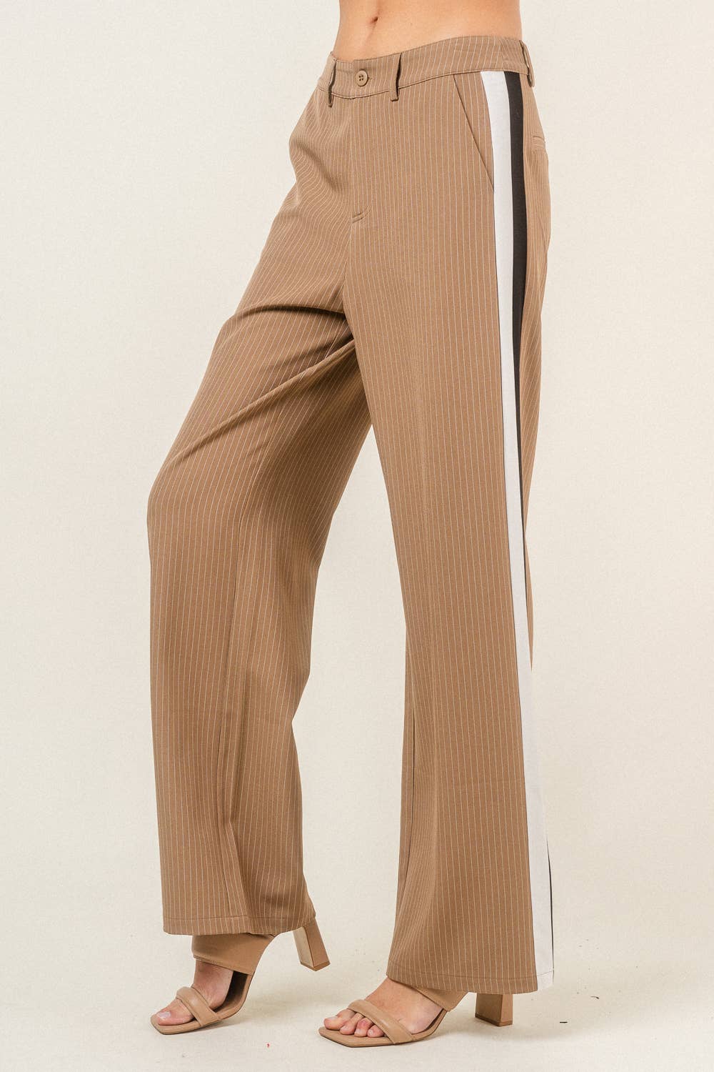 Tan pants with a white stripe on a beige background