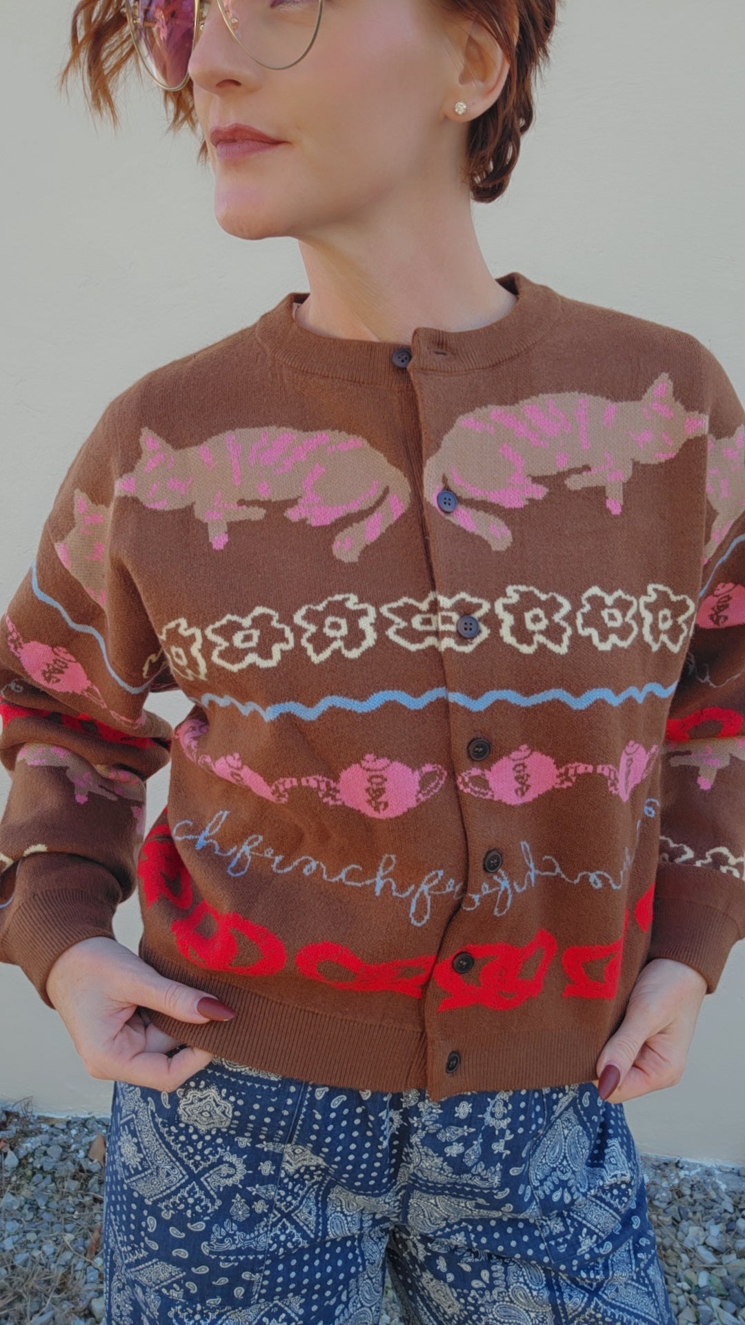 Person wearing a brown sweater with pink fish pattern