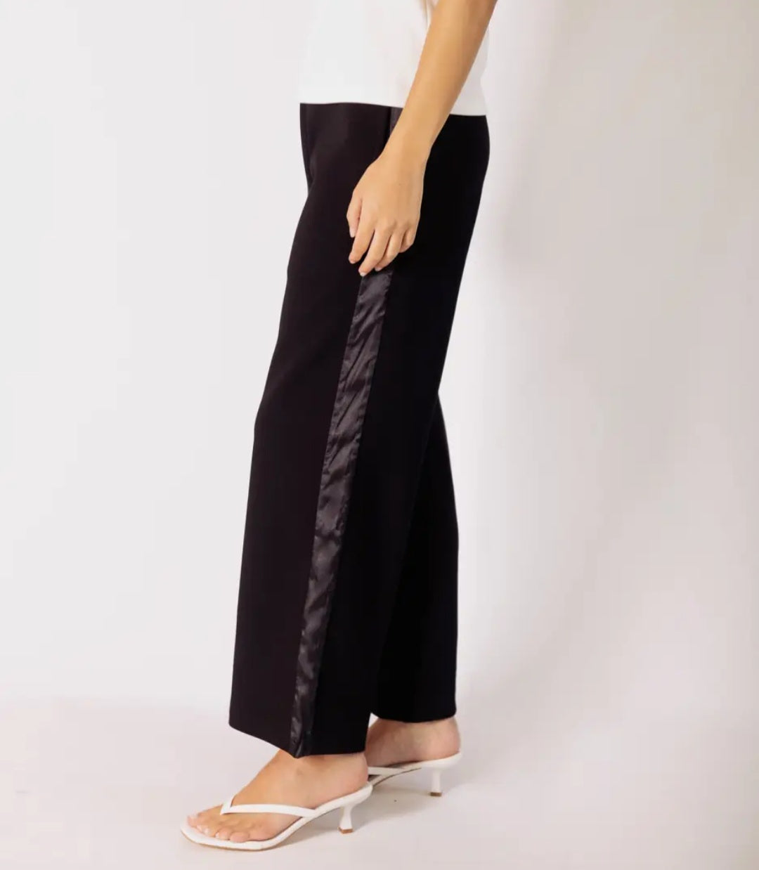 Black wide-leg pants worn by a person on a white background
