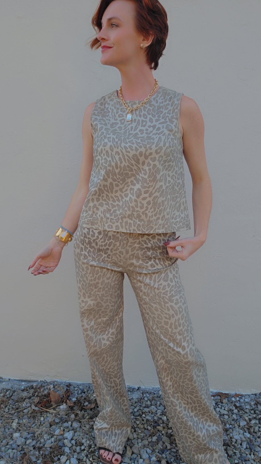 Woman wearing a leopard print outfit against a plain background